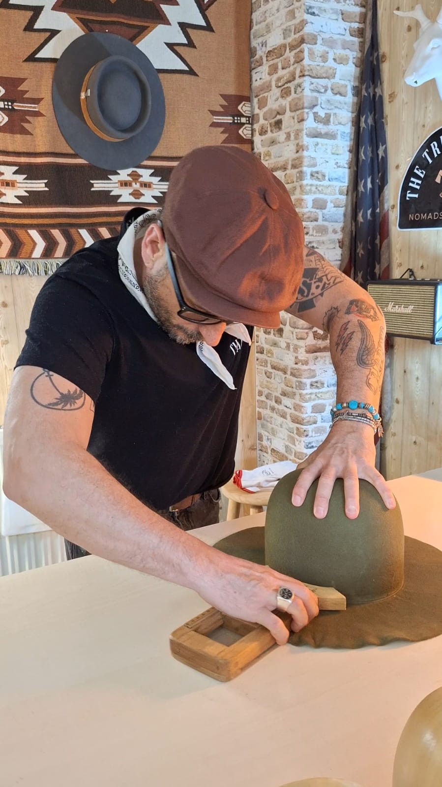 Artesano dando forma al ala de un sombrero con una herramienta de madera
